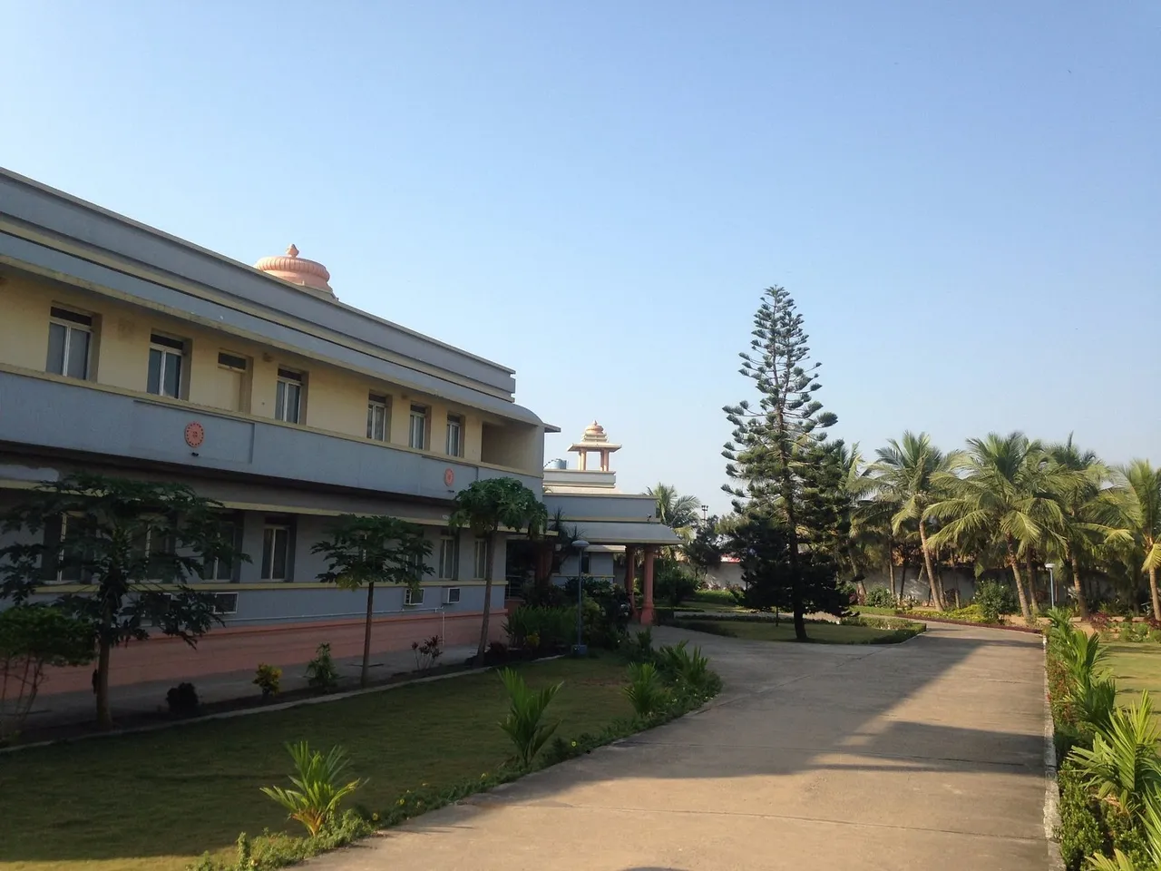 Birla Guest House building and lawn in the morning light, with the walkway to the entrance